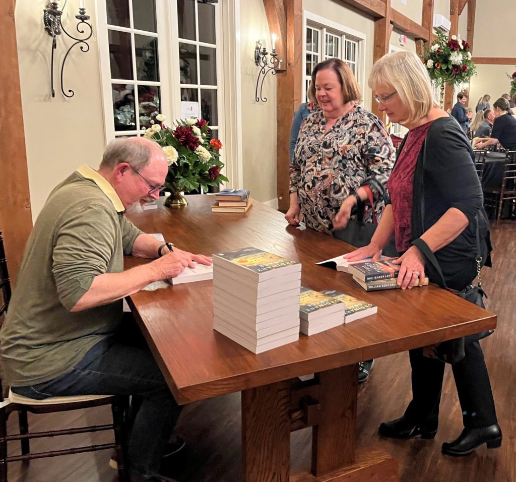 Author William Kent Krueger signing a book at Louisburg Library event