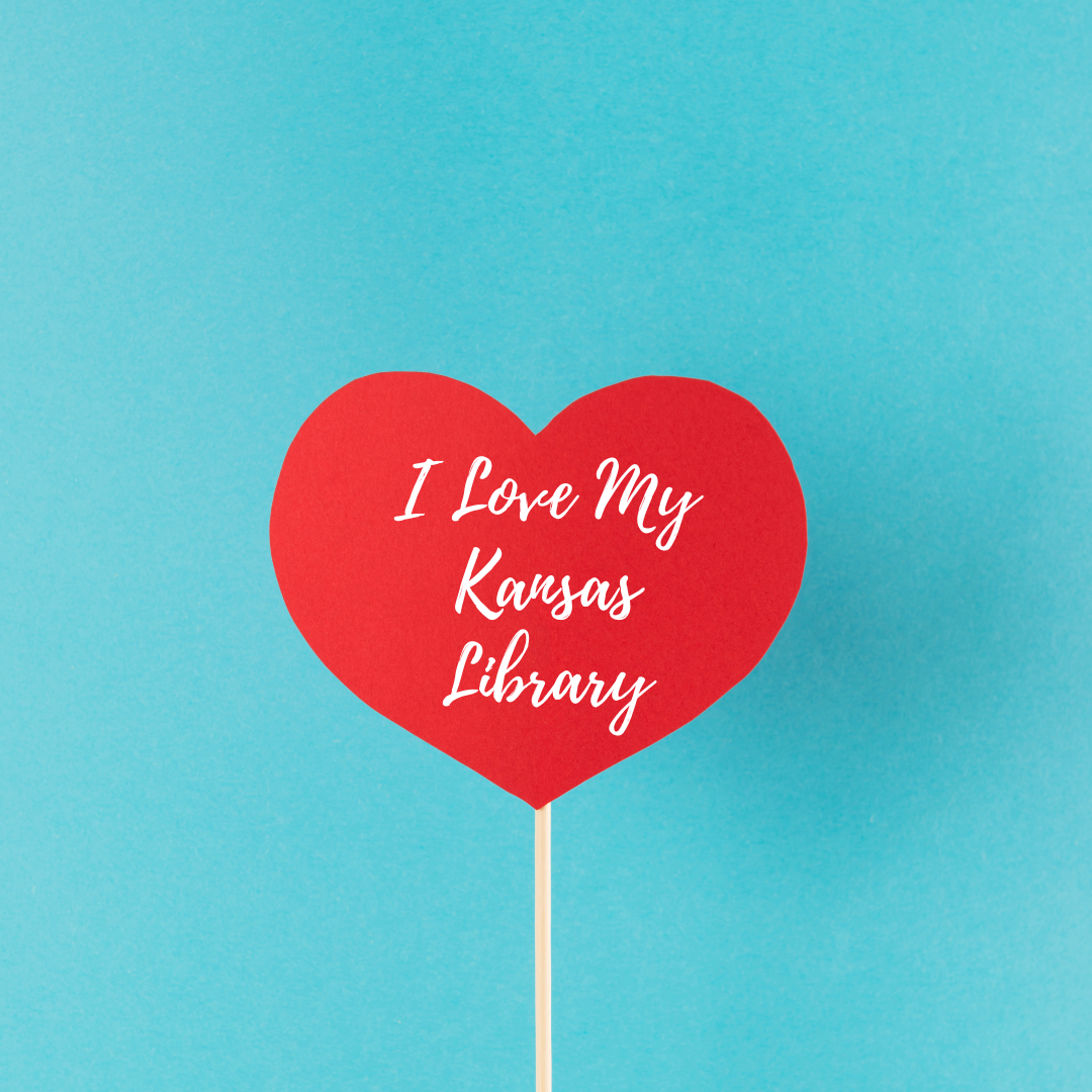 The text I l Love My Kansas Library on a red heart lolipop